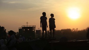 Children displaced by the fighting in Bor county, who have just arrived, are standing on the side of a boat in the port in Minkaman